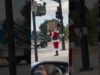 A man dressed as santa claus holding up a sign.