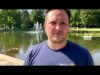 A man standing in front of a pond with water jets.