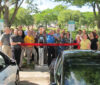 A group of people standing around a car.