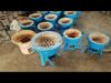 A group of blue pots sitting on top of cement.