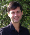 A man with black shirt and brown hair.
