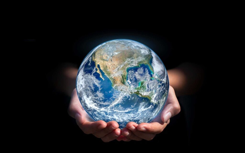A person holding an earth globe in their hands.