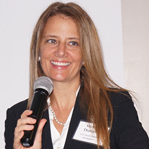 A woman holding a microphone and wearing a suit.